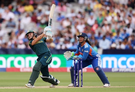 Ash Gardner in her follow-through and Richa Ghosh, the India wicketkeeper, watch the ball, out of picture, fly away