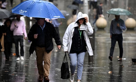 People are seen as rain falls in Sydney.