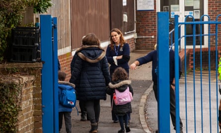 Headteacher Flora Cooper welcomes children arriving at the school.