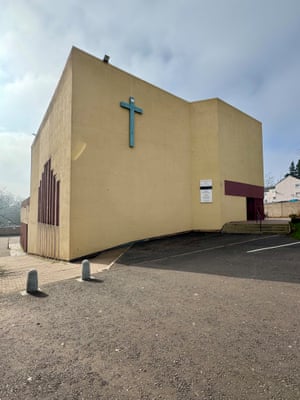 A church built to a blocky design with mustard-coloured rendered brick