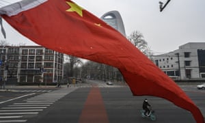 A Chinese commuter rides through a nearly empty intersection during the afternoon rush hour on March 6, 2020 in Beijing, China.