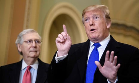 Mitch McConnell listens while Donald Trump speaks to reporters before a meeting with Senate Republicans in Washington DC, 26 March 2019.