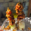 Chicken pieces on skewers that are placed upright into half an onion.