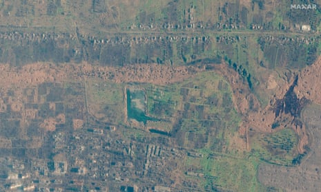 A destroyed housing area and fields pockmarked with craters.