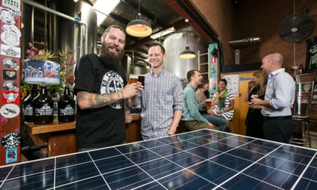Oscar McMahon of Young Henrys and Jake Steele of Solargain pose at the Young Henrys brewery with one of the solar panels to be installed as part of a community solar project.