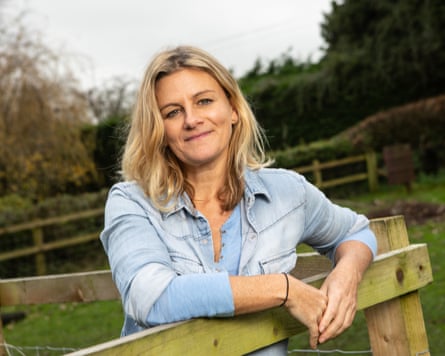 Zelda Perkins leaning against a fence and smiling at the camera