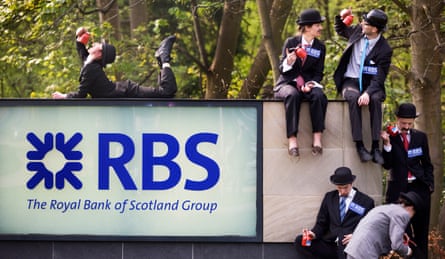 People dressed in business suits and bowler hats sit with oil cans