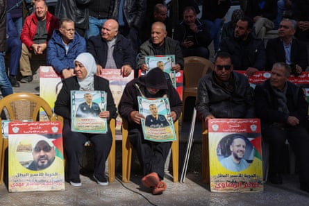 People lift placards bearing portraits of Palestinians detained by Israel, including Hussam Abu Safiya