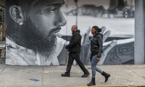People walk past a mural of American rapper Nipsey Hussle in the Bushwick neighbourhood of Brooklyn.
