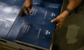 A worker stacks newly printed federal budget papers in Canberra on Sunday