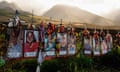 Full-size color images laminated of people on fence with ribbons and white crosses, with mountain and sun breaking through mist beyond it.