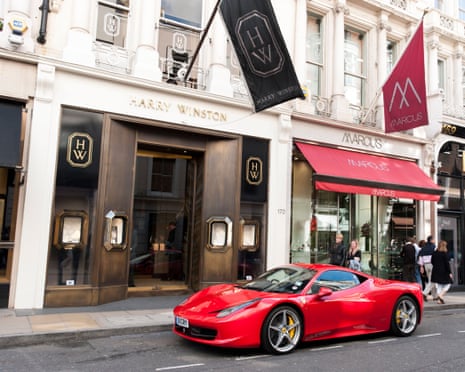 Red Ferrari car parked on New Bond Street, London