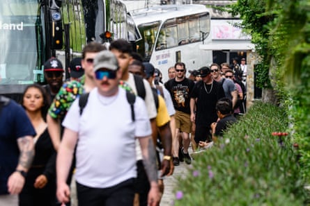 Line of people walking away from a number of coaches