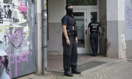 Masked police guard a house in Berlin on Wednesday after raids on several properties in connection with the gold coin heist.