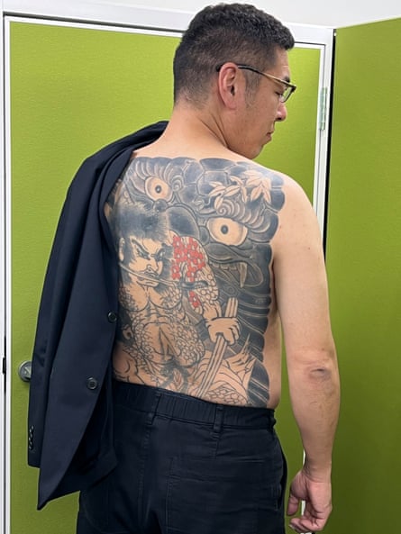 Yoshitomo Morohashi, a former yakuza member who became a defence lawyer, shows his tattoo at his office in Tokyo.