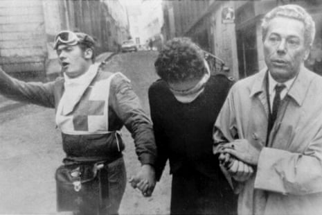 Jacques Monod, right, winner of the 1965 Nobel Prize for medicine, comforts a student who was wounded in her eyes during a night-long battle between police and students in the Latin Quarter of Paris, France, May 11, 1968, as a Red Cross worker calls for help.