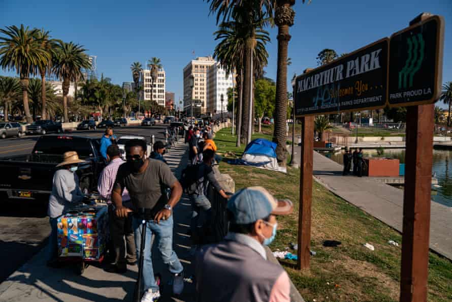People gather to watch police activity at MacArthur Park in Los Angeles on 2 April.