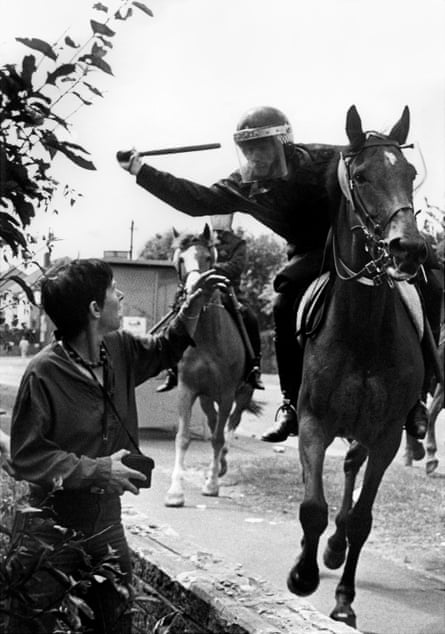 A mounted police officer aiming at Lesley Boulton with his baton