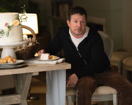 Michael J. Fox sitting at a table eating cake