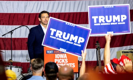 Ron DeSantis looks into the crowd after speaking as supporters of former US president Donald Trump hold up signs during a barbecue fundraiser in Cedar Rapids, Iowa, on Sunday.
