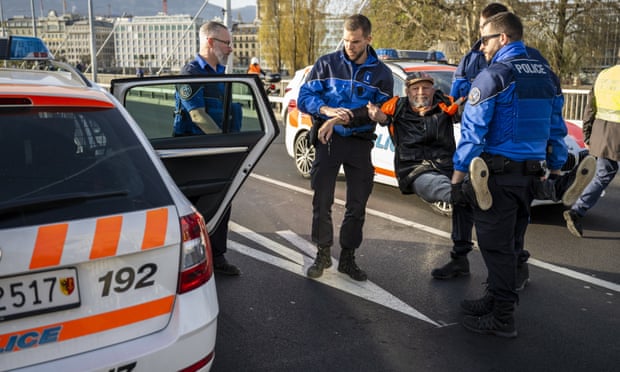 Police officers arrest a climate activist during a roadblock protest action at the Mont-Blanc Bridge in Geneva, Switzerland in April.