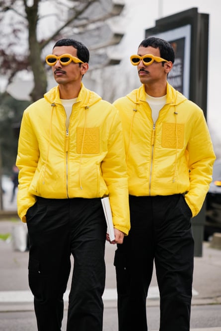 Two men in bright yellow jackets and sunglasses with bright orange frames