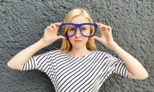 Young blonde woman wearing large blue novelty glasses