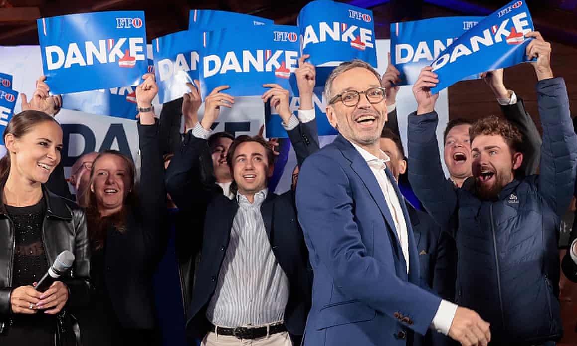 Herbert Kickl surrounded by people holding aloft blue ‘Danke’ placards