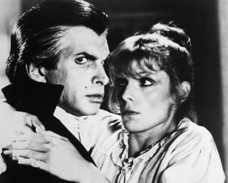 George Hamilton embraces Susan Saint James, both gazing intently off to the side