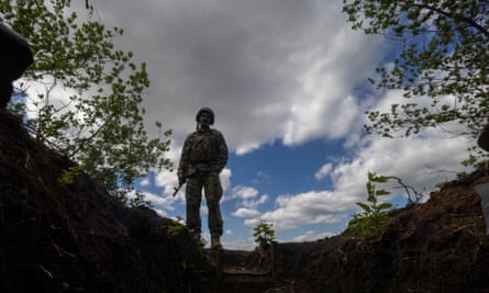 A Ukrainian soldier stands near an artillery position on the outskirts of Chasiv Yar