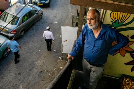 Nasser Rajabi stands on a balcony above the street