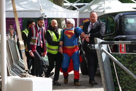 Security detaining Tim Penrose in his Superman outfit.