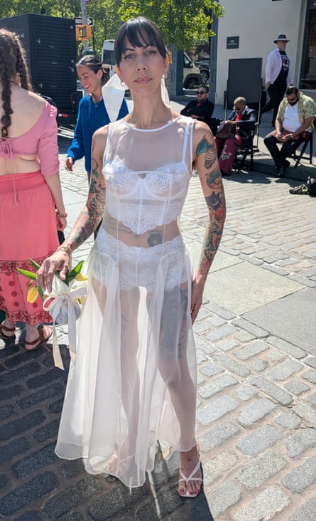 woman in sheer white dress with white lace undergarments stands outside