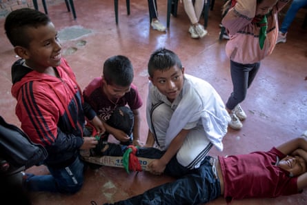 The children are taught how to stabilize a leg injury