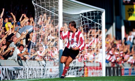 Matt Le Tissier with ball in hand as he pumps his fist in front of the crowd behind the goal after scoring