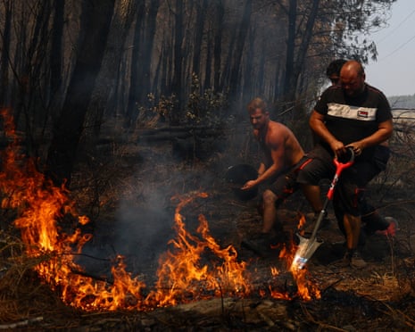 People work to extinguish a wildfire, in Lanton, Gironde department, amid drought conditions following a heatwave and water shortages across much of France.