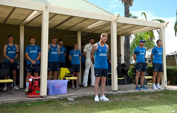 England players and staff stand for a moment’s silence in memory of Shane Warne during their tour match in Antigua.