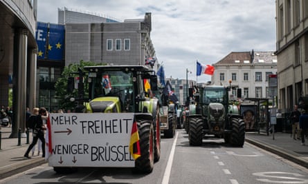 Tractors drive down a street in Brussels