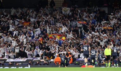 Fans of Real Madrid celebrate after Vinicius Junior scores his team's first goal at Manchester City.