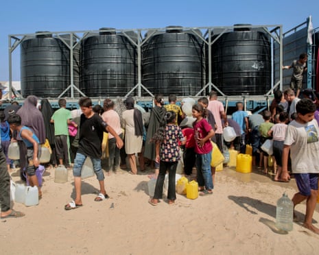 People in the Mawasi area of Khan Younis try to fill water tanks as Gaza faces a heatwave.