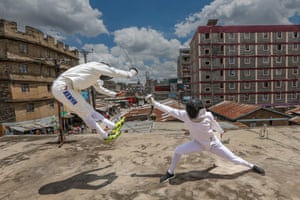 Professional fencer Isaac Mburu Wanyoike, left, jumps backwards while training teenage members of the Tsavora fencing club on a rooftop in Mathare, Nairobi