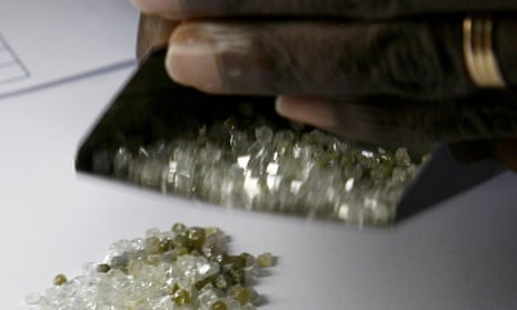 A man checks raw diamonds at the gold and diamond department at Sierra Leone Central Bank in Freetown.