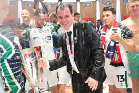 Sunderland head coach Régis Le Bris is soaked with champagne as the team celebrate in the dressing room after winning the Championship playoff final