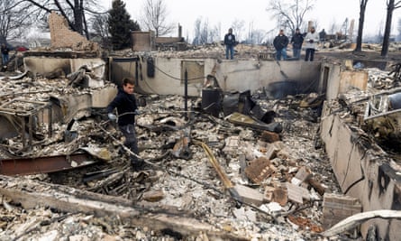 Anthony D-Amario, 18, looks through the remains of his home destroyed by the Marshall Fire as his family and friends watch in Louisville, Colorado, on Friday.