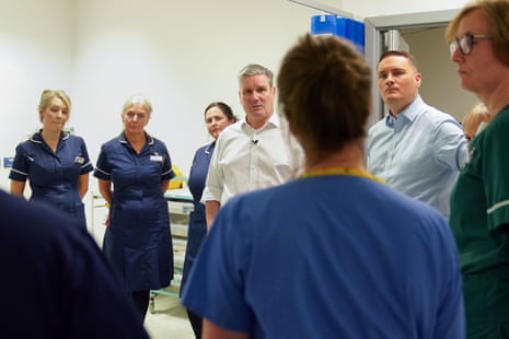 Keir Starmer (white shirt) and Wes Streeting (blue shirt) talking to staff in the Bexley Wing of St James' University Hospital in Leeds today.