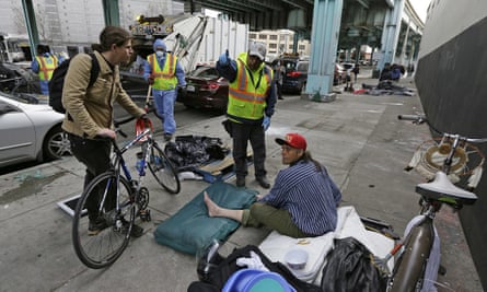 A San Francisco city worker asks a homeless man to leave the area to make room for cleaning in February 2016.