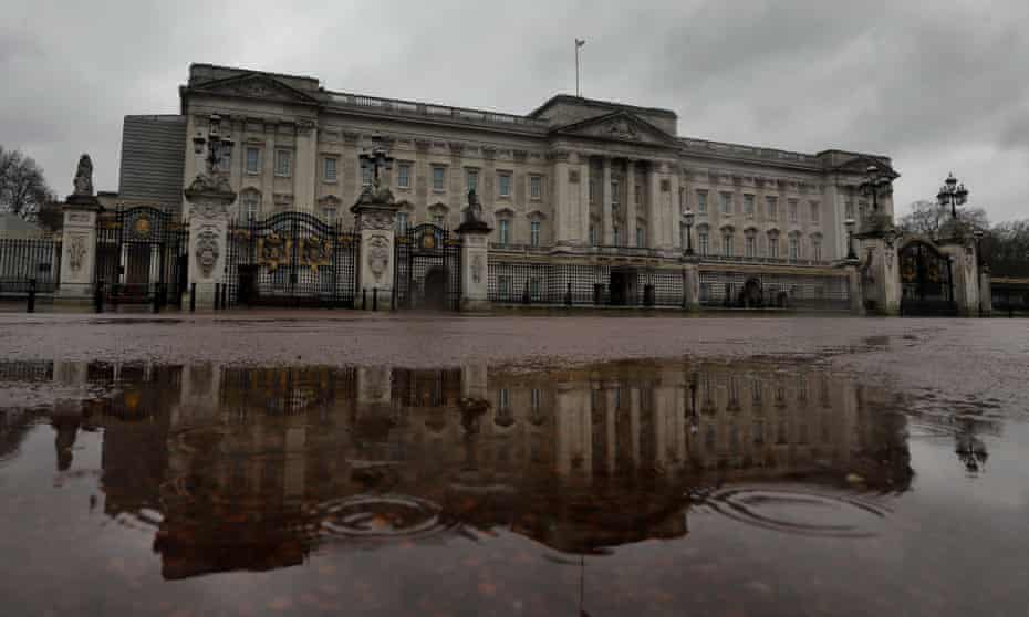 Buckingham Palace is reflected in a rain puddle in London
