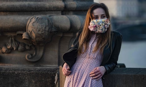 CZECH-HEALTH-VIRUS<br>A woman wearing a face mask stands on the Charles Bridge on March 28, 2020, in Prague, where most activities slowed down or came to a halt due to the spread of the novel coronavirus COVID-19. (Photo by Michal Cizek / AFP) (Photo by MICHAL CIZEK/AFP via Getty Images)