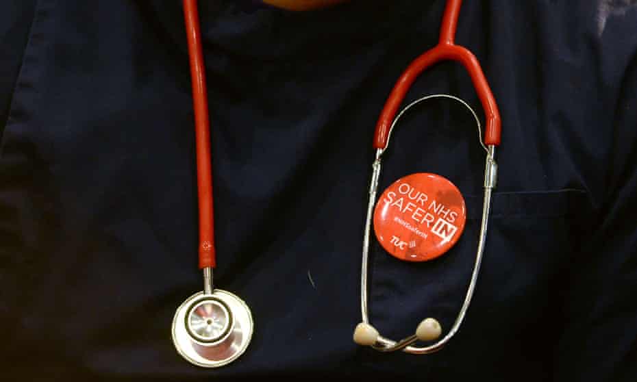 A health worker wears a badge that reads ‘NHS safer in the EU’.