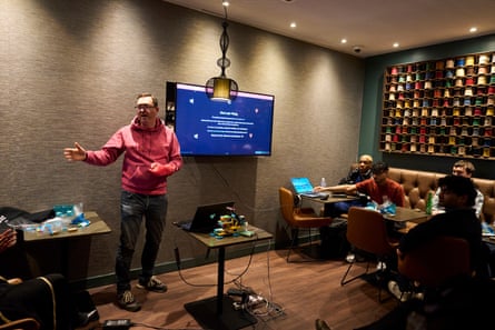Man standing by a screen giving a talk